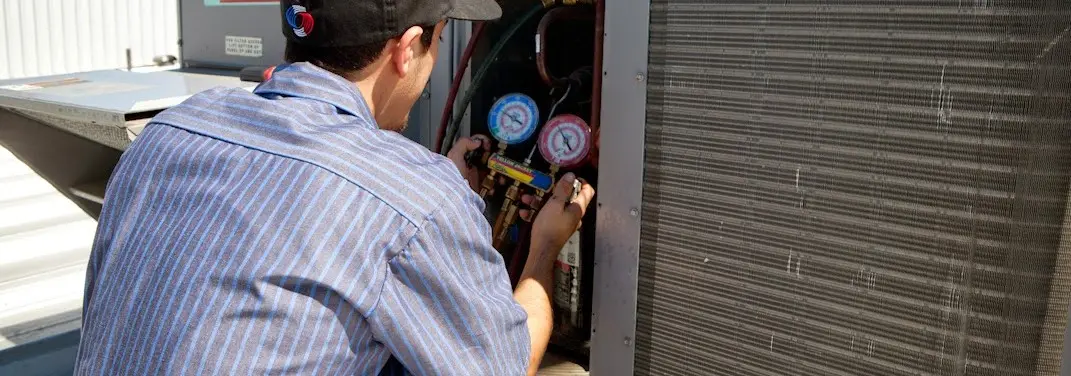 HVAC technician servicing a condenser unit in Hiram